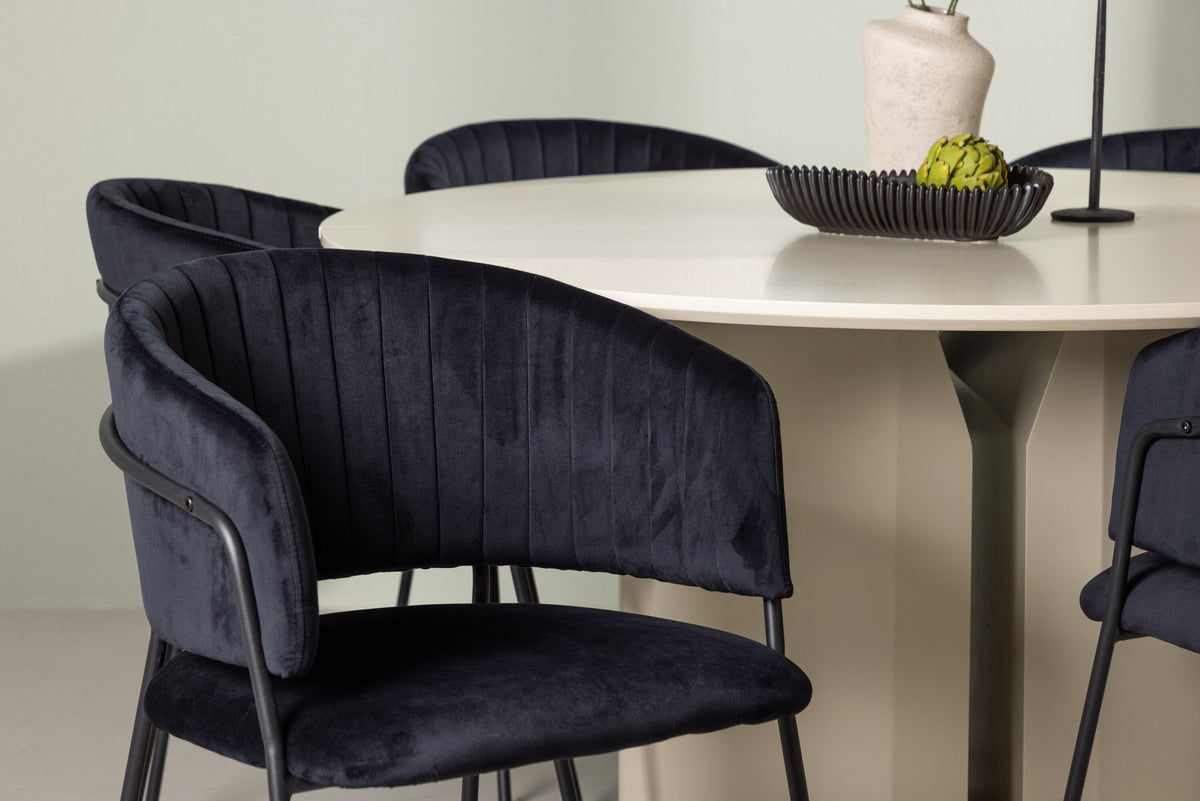 Esszimmerset Selma & Sandvik von Venture Home: zwei schwarze Stühle mit Samtbezug und ein runder Esstisch mit beiger MDF-Tischplatte.