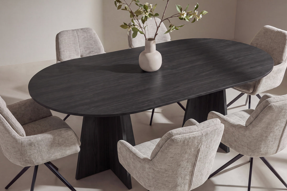 Ovaler Esstisch aus MDF mit Furnier in Schwarz und Metallbeinen, dazu zwei Esszimmerstühle mit braunem Polyesterbezug und schwarzen Beinen.