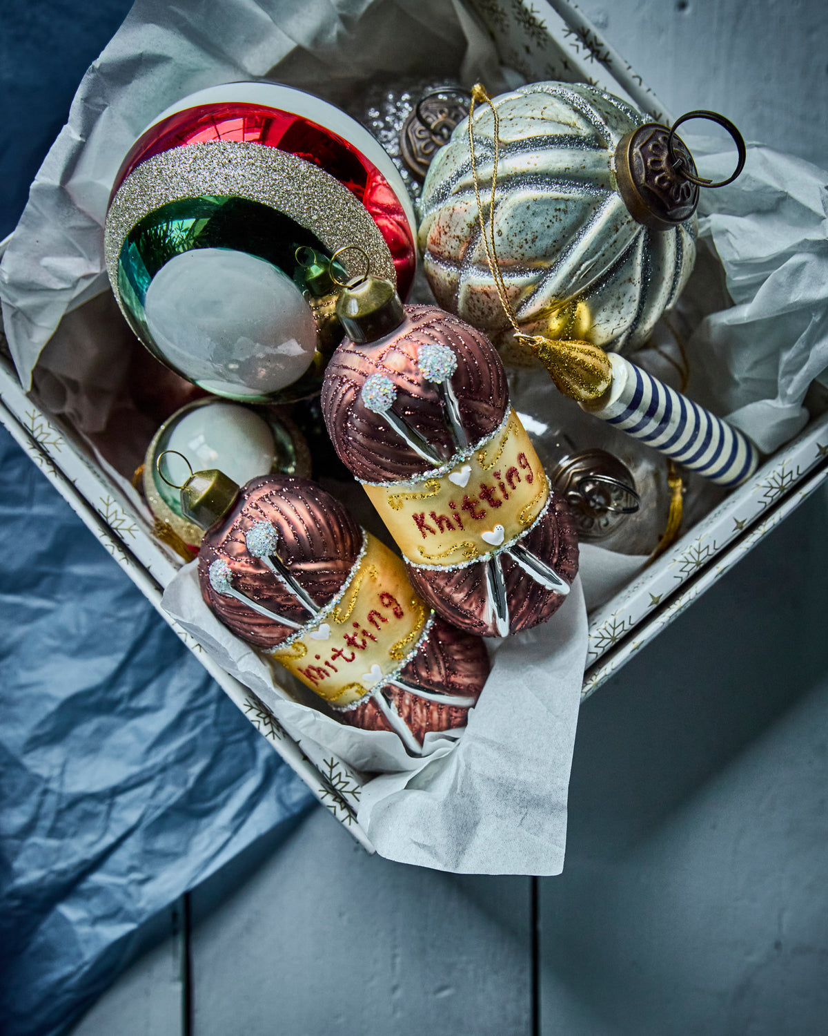 Zwei braune Glas-Ornamente HDWrench in Form von Wollknäueln mit Stricknadeln