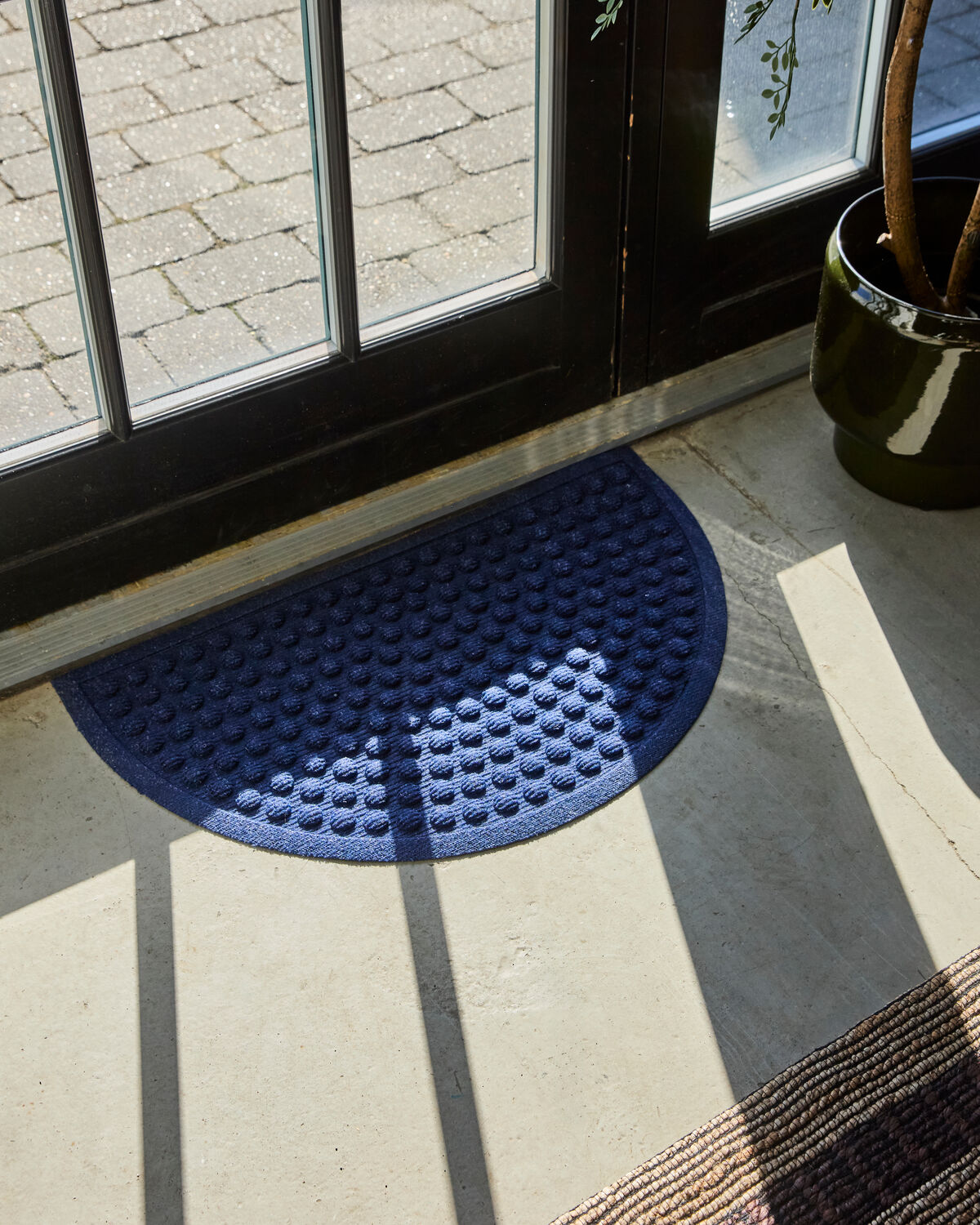 Elegante halbmondförmige Fußmatte in Blau von House Doctor, ideal für den Eingangsbereich und als stilvolle Akzentuierung.