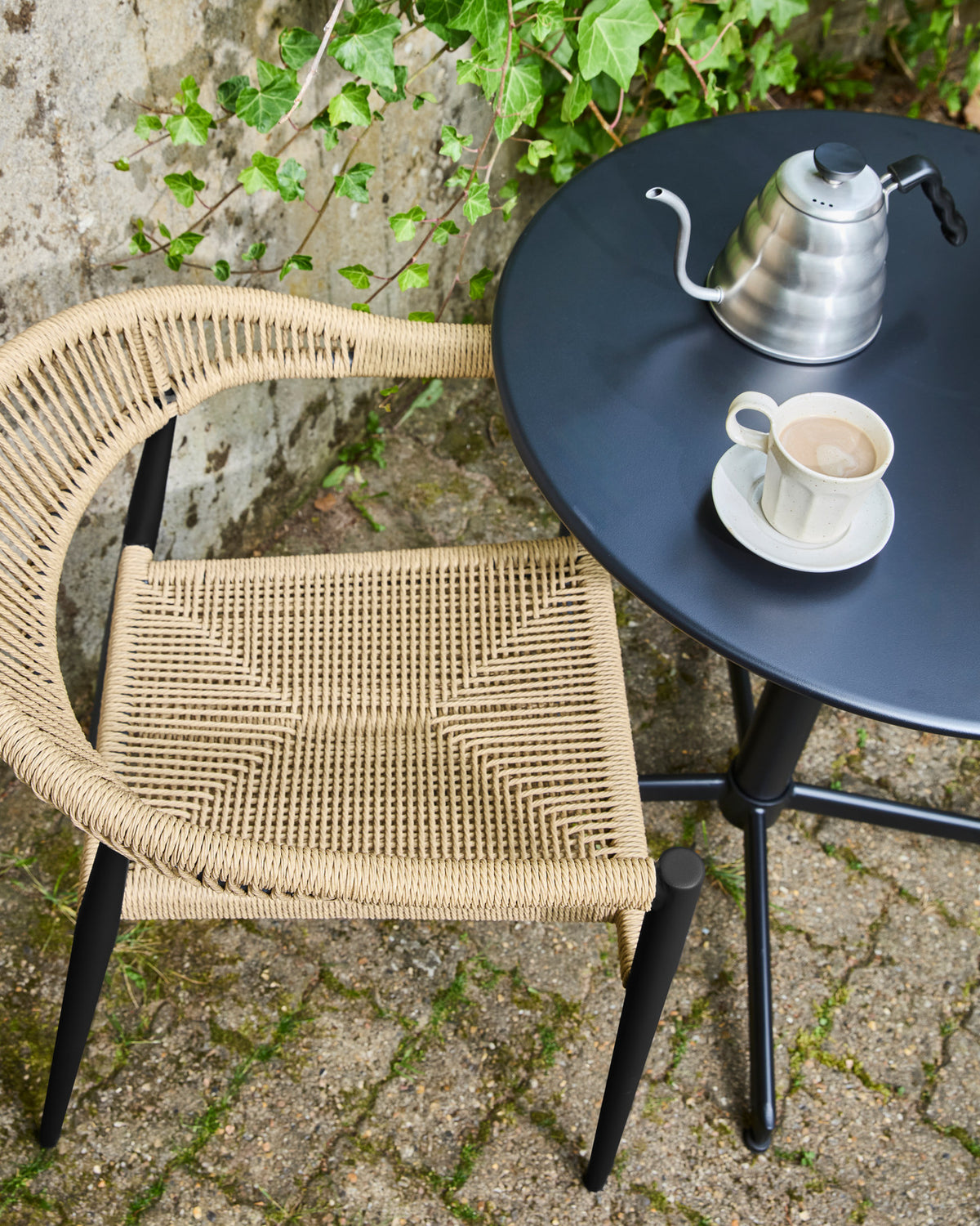 Gartenstuhl HDCoon mit schwarzem Aluminiumgestell und hellem, geflochtenem Sitz und Rückenlehne