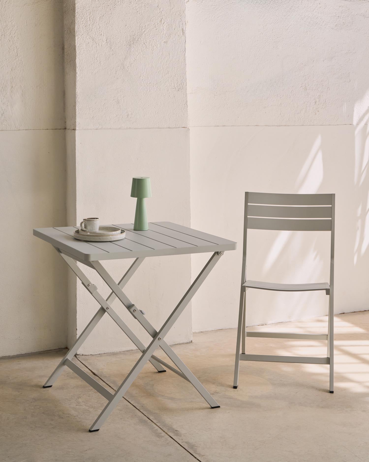 Entdecken Sie den eleganten, faltbaren Gartentisch Torreta von Kave Home. Mit 70 x 70 cm und wetterfestem Aluminium ist er perfekt für kleine Terrassen.