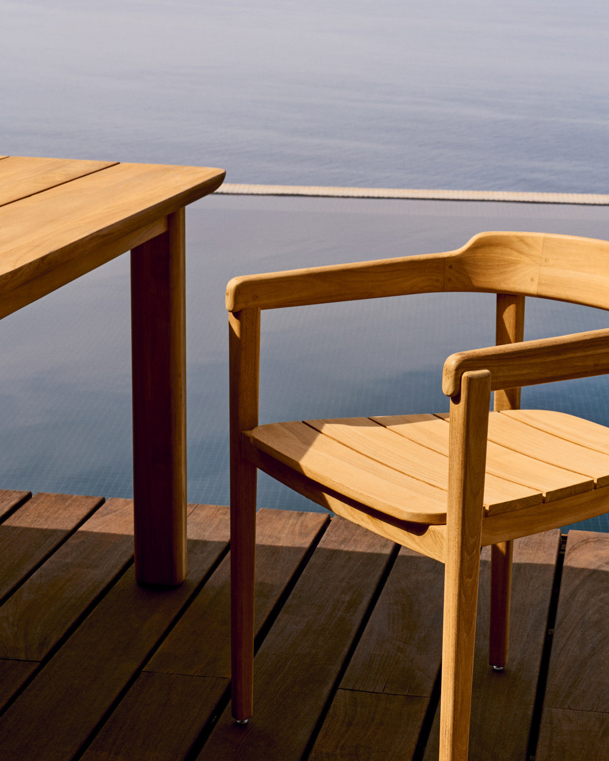 Stapelbarer Stuhl Icaro aus massivem Teakholz mit natürlichem Finish FSC 100% in Natur präsentiert im Onlineshop von KAQTU Design AG. Gartenstuhl mit Armlehnen ist von Kave Home