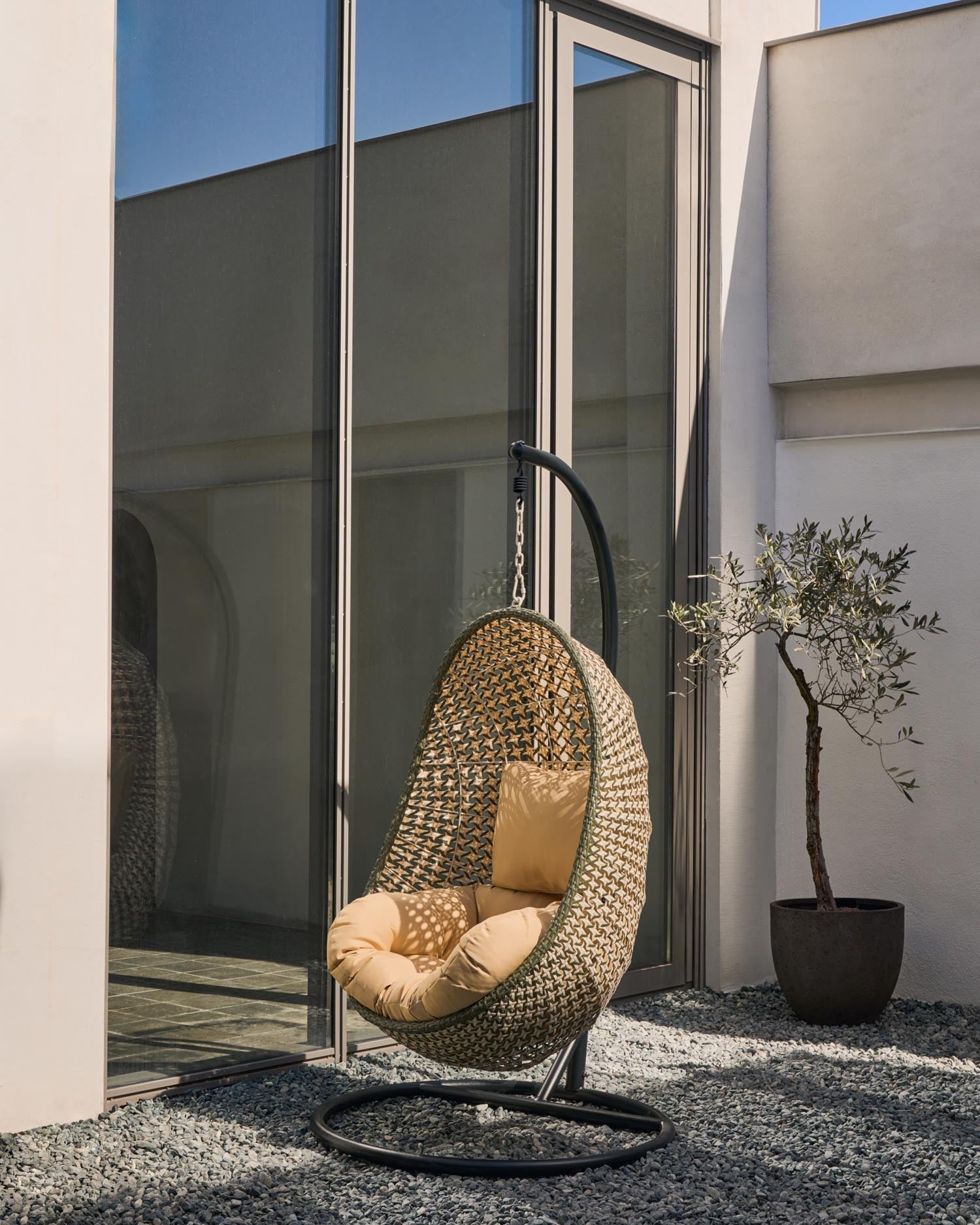 Der Hängesessel Cira vereint exotisches Flair mit Komfort, ideal für drinnen und draußen, mit stabilem Standfuß und weichen Kissen.