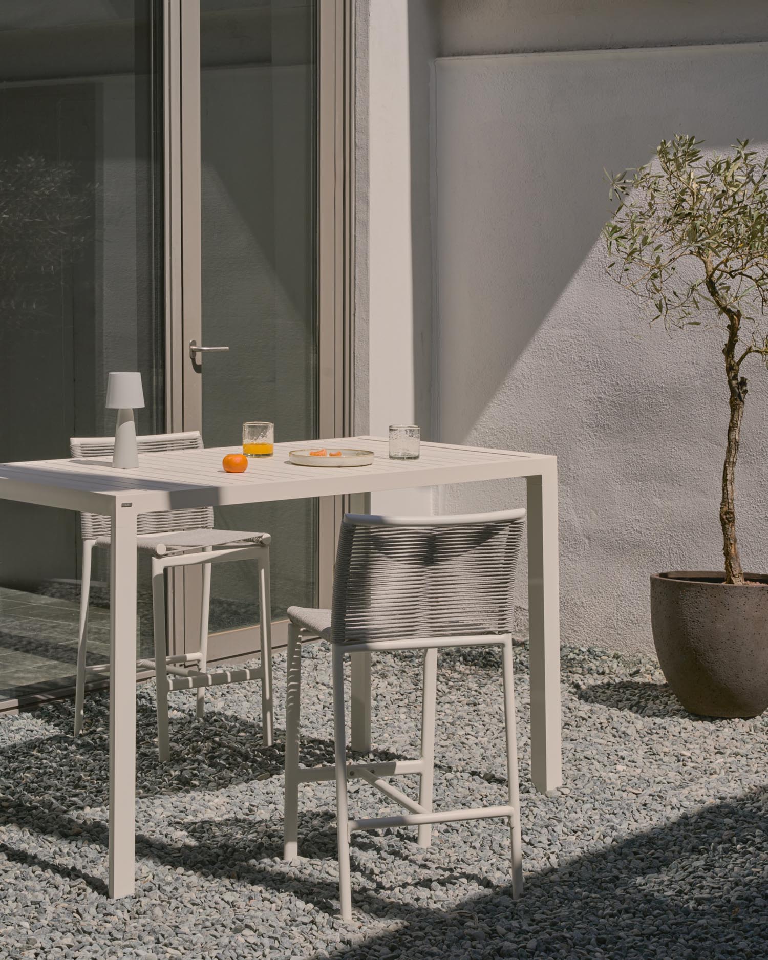 Der Culip Outdoor-Hocker vereint modernes Design mit Komfort: weißes Aluminium und geflochtenes Seil für stilvolle Entspannung im Freien.