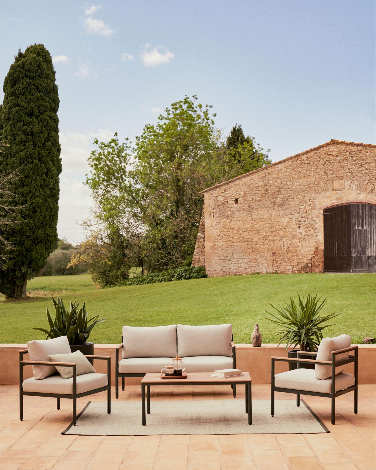 Entspannen Sie stilvoll im Freien mit dem Aiguafreda Set: 2-Sitzer-Sofa, 2 Sessel und ein robuster Couchtisch aus FSC-zertifiziertem Akazienholz.