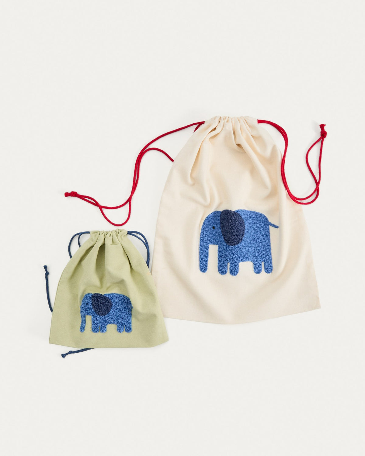 Zwei Taschen aus Baumwolle in Beige und Grün, jede mit einem aufgestickten blauen Elefanten, handgefertigt für Kinder.