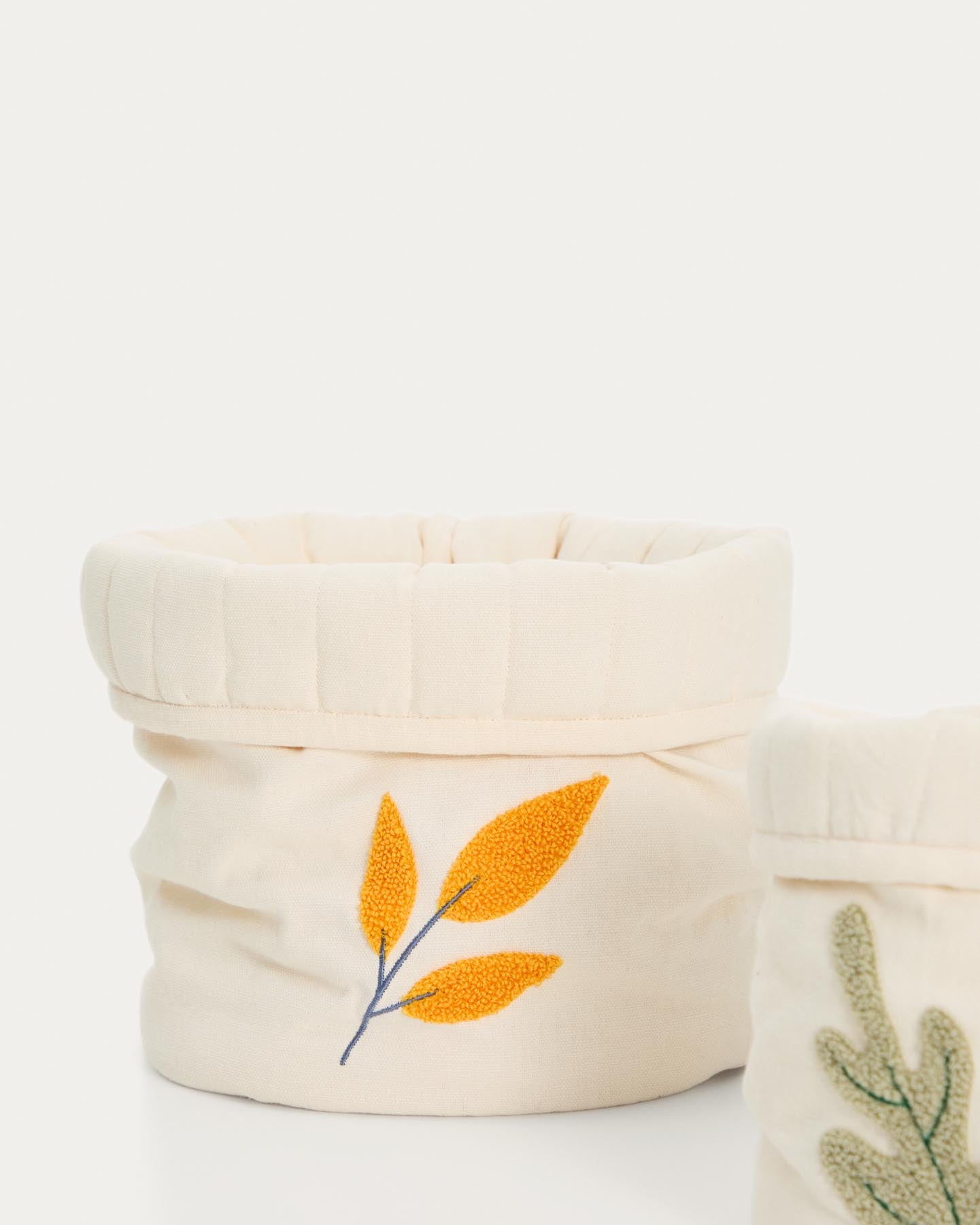 Kinderkörbe Tandani im 2er-Set aus Baumwolle in Beige mit aufgestickten Blättern in Weiß präsentiert im Onlineshop von KAQTU Design AG. Aufbewahrungskorb ist von Kave Home