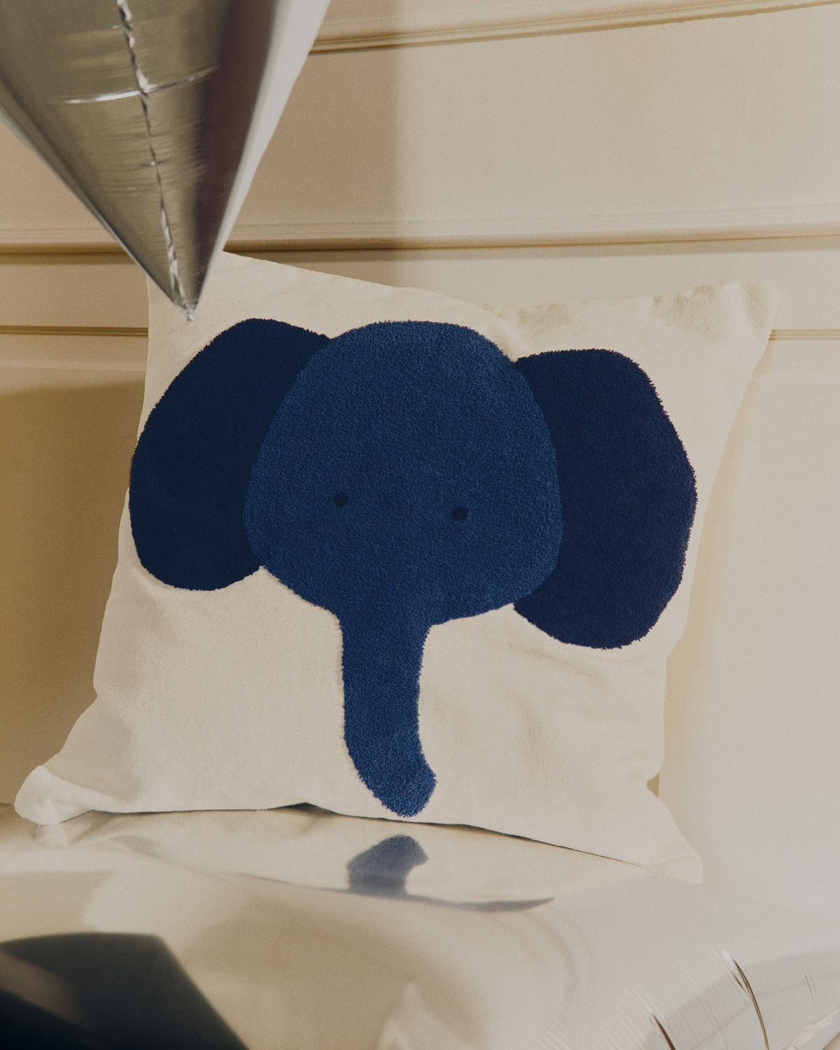 Beigefarbene Bodenkissenhülle aus Baumwolle mit aufgesticktem blauem Elefantenmotiv, quadratische Form, 70 x 70 cm.