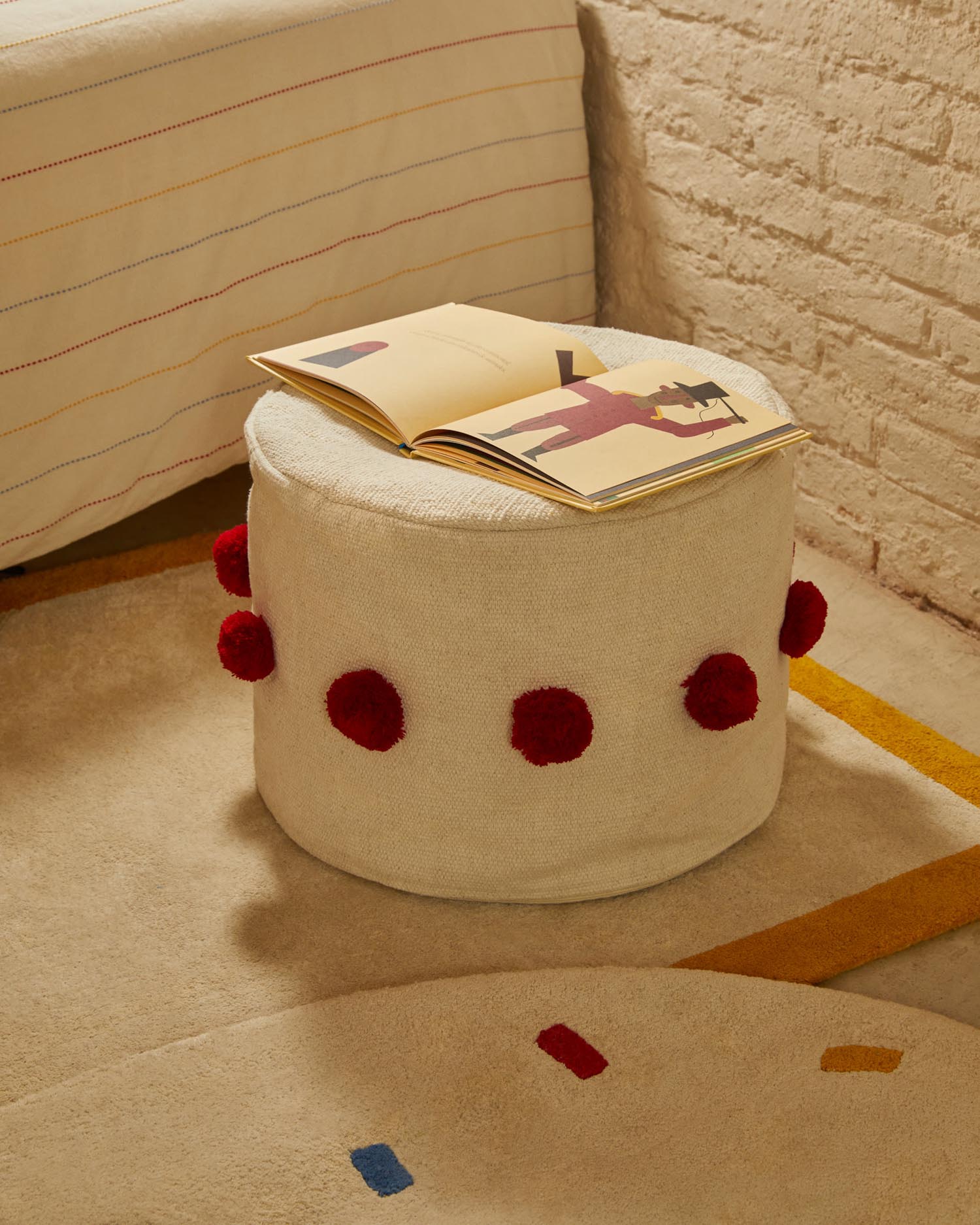 Sitzsack Manua aus beiger Baumwolle mit roten Quasten, Ø 40 cm, von Kave Home. Komfortabel und dekorativ für Ihr Zuhause.