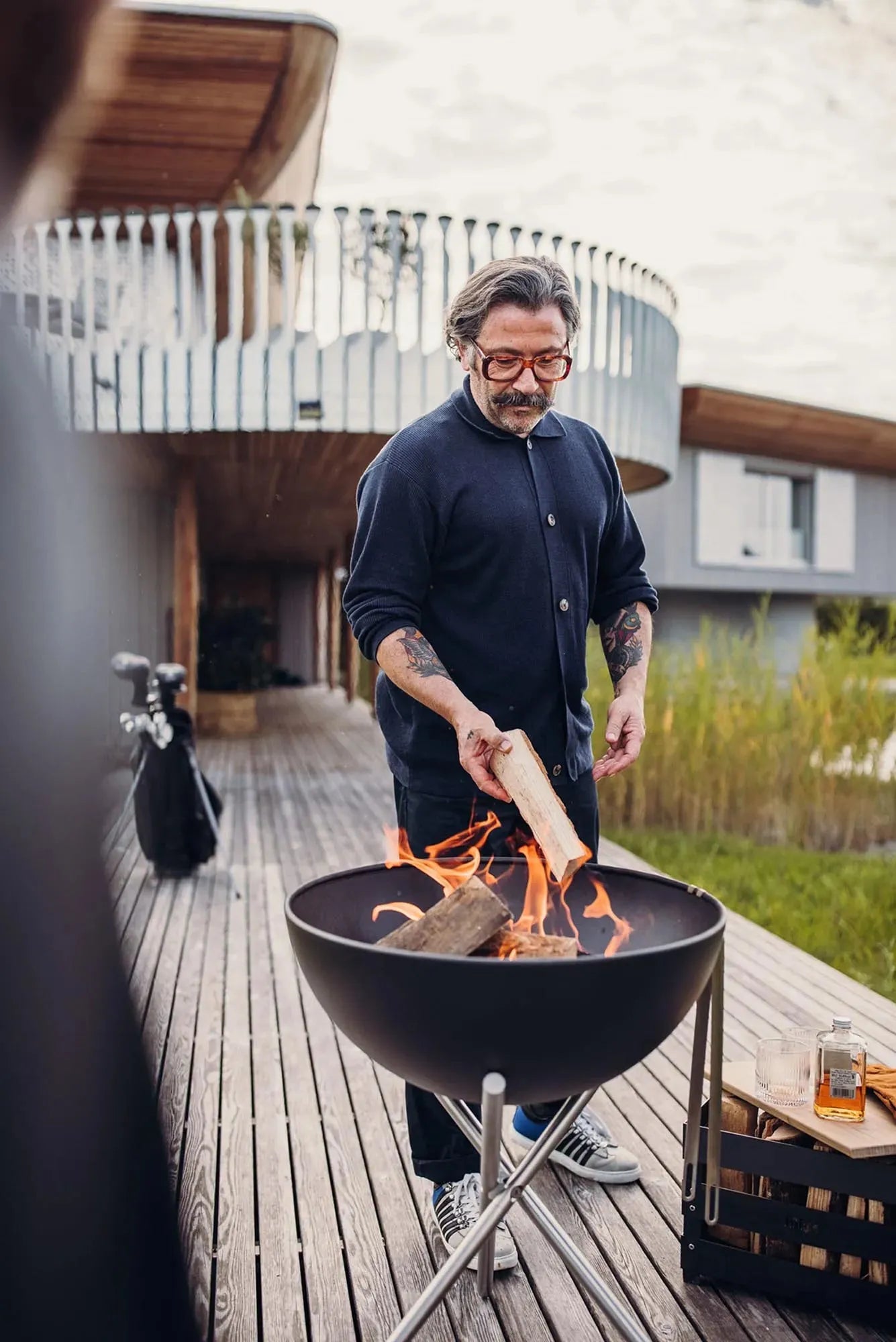 Die BOWL 57 Feuerschale von Höfats: schwebende Stahlhalbkugel, multifunktional, ideal zum Grillen, stabil auf Edelstahl-Dreibein.