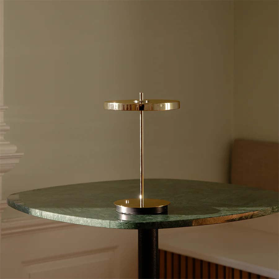 Die Asteria Move Tischleuchte von Umage ist eine kabellose, tragbare LED-Lampe mit blendfreiem Licht, einstellbarer Helligkeit und langer Akkulaufzeit.