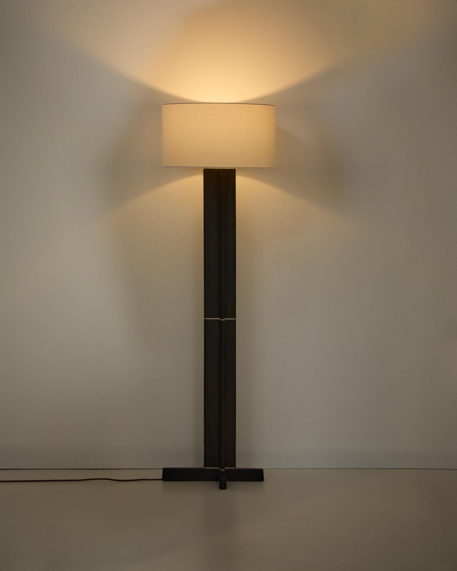 Elegante Stehlampe Niani aus Kautschukholz mit edlem dunklen Finish und sanftem elfenbeinfarbenem Baumwollschirm, perfekt für gemütliche Atmosphären.