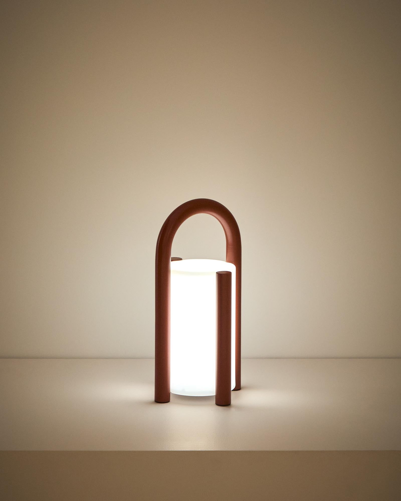 Kleine, stilvolle Tischlampe Leros aus langlebigem Polyethylen und terrakottafarbenem Stahl, ideal für gemütliche Outdoor-Atmosphäre.