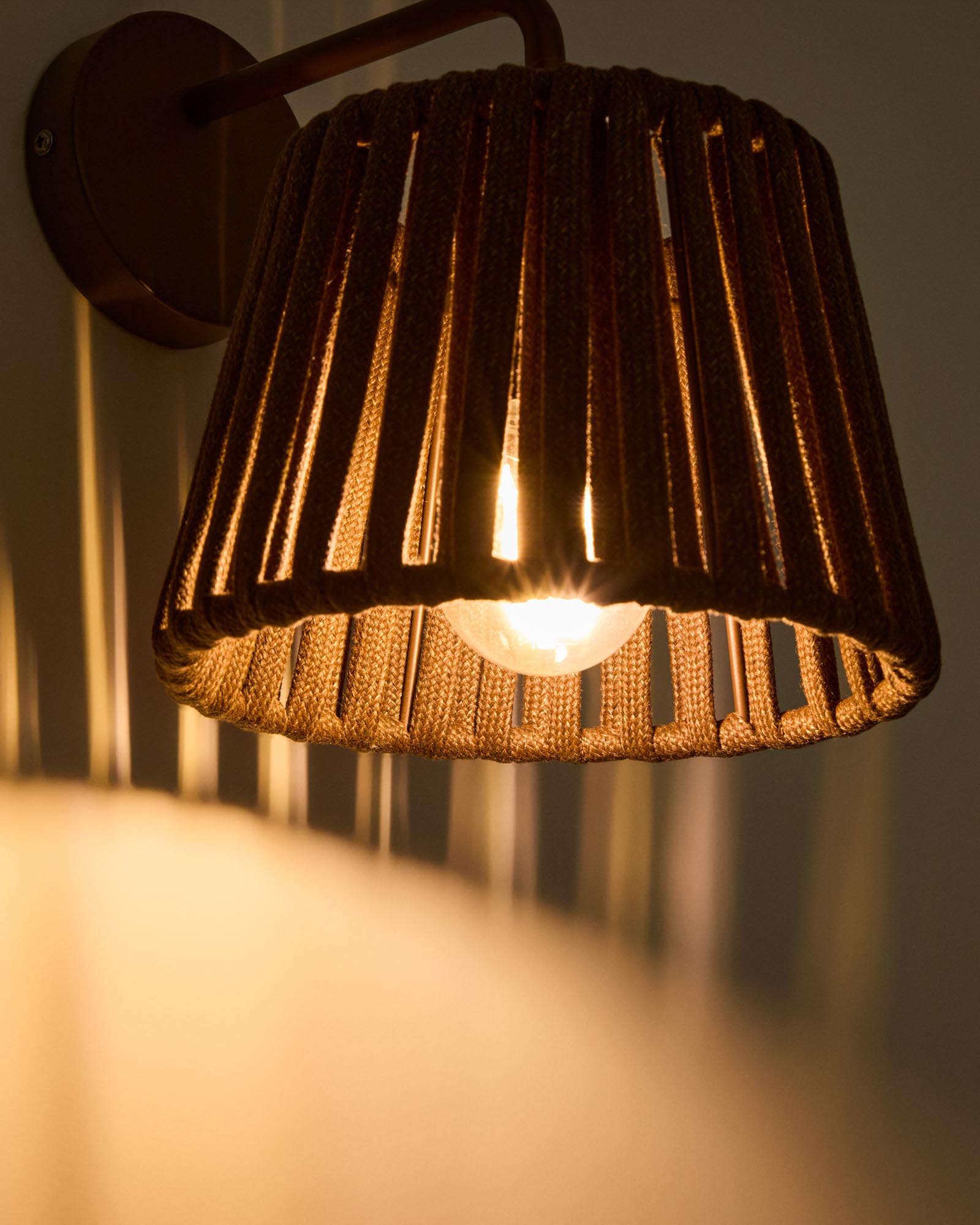 Stilvolle Outdoor-Wandleuchte Aldet aus robustem Seil und elegantem braunem Metall, ideal für stimmungsvolle Außenbereiche.