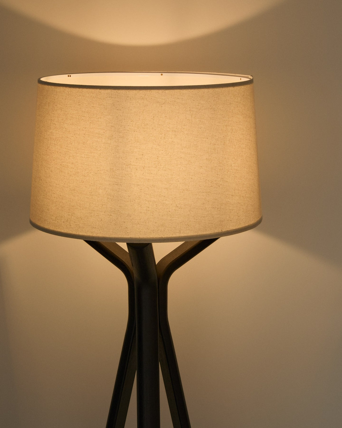 Stehlampe Ubira mit stativförmigem Sockel aus Eschenholz, schwarzem Finish und Lampenschirm aus Leinen, mit Fussschalter ausgestattet.
