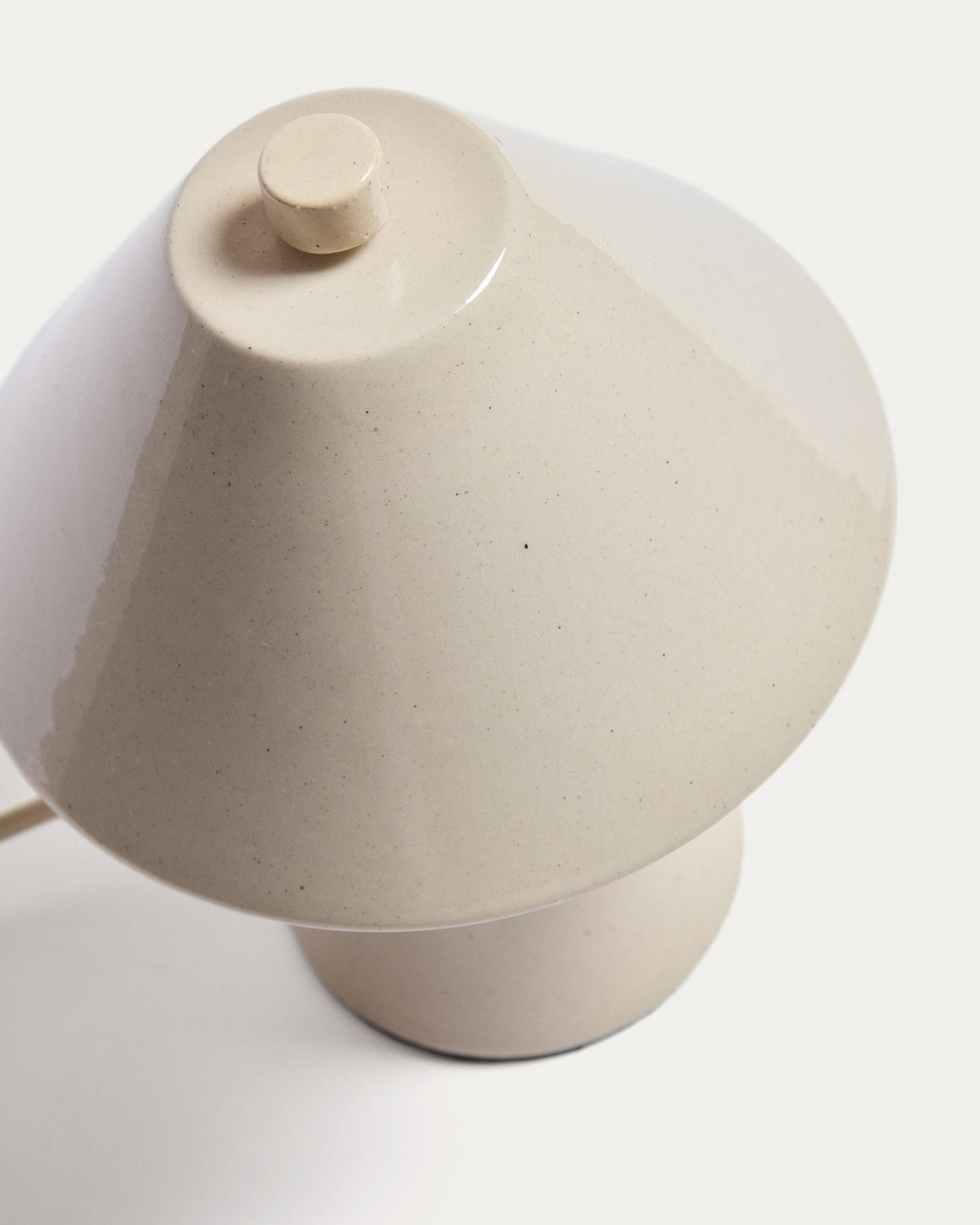 Tischleuchte Ceren aus beiger Keramik, zylindrische Form, Höhe 21 cm, mit Handschalter, Ansicht von vorne auf hellem Hintergrund.