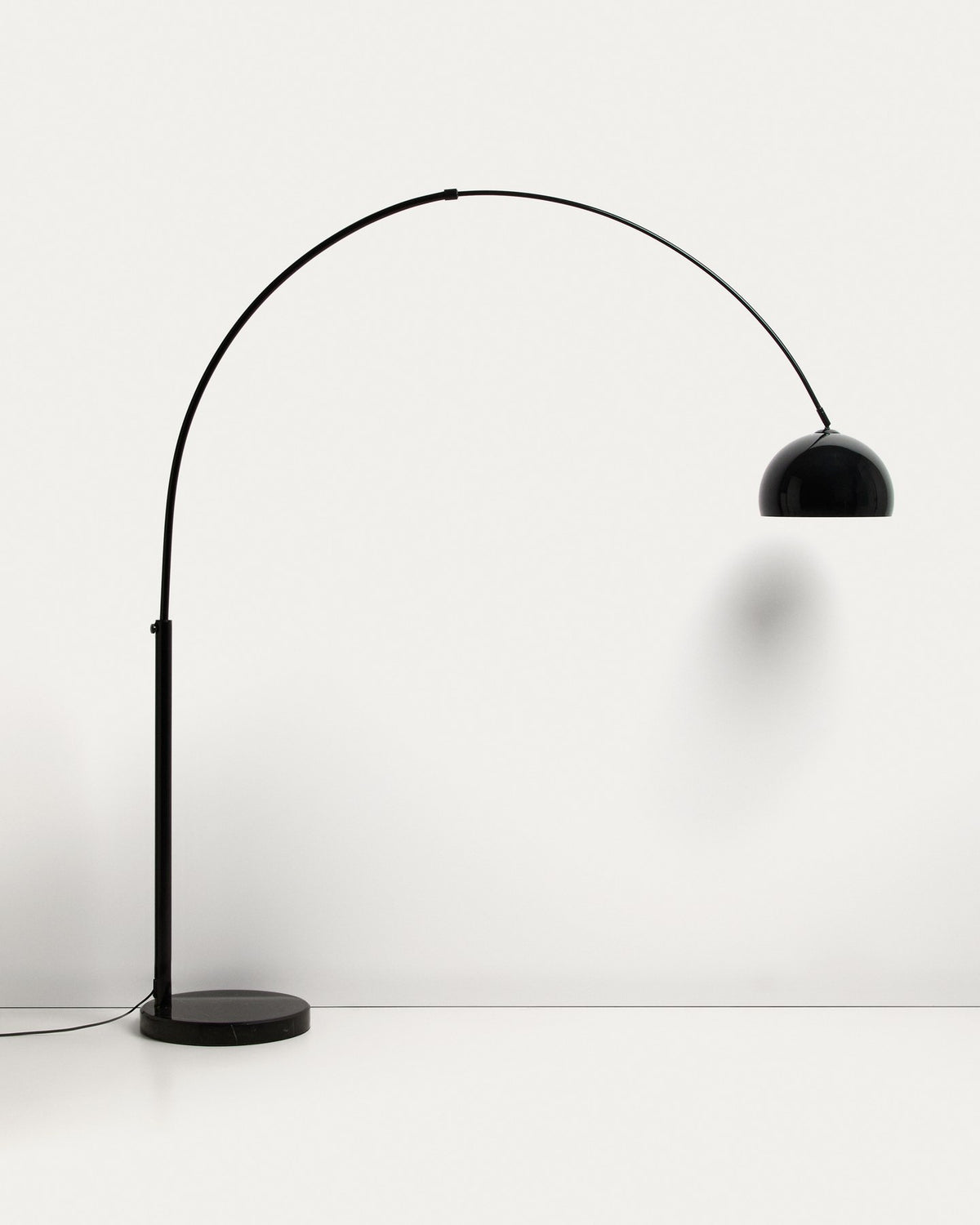 Stehlampe Madali aus glänzend schwarzem Stahl mit gebogener Struktur und massivem Fuss aus schwarzem Marmor, schwenkbarer Lampenschirm.