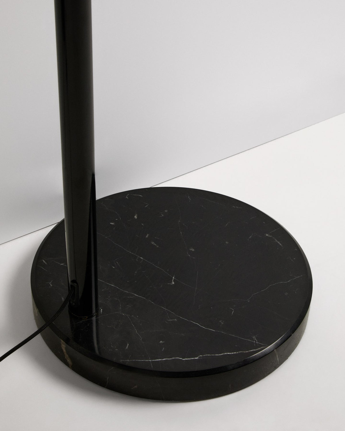 Stehlampe Madali aus glänzend schwarzem Stahl mit gebogener Struktur und massivem Fuss aus schwarzem Marmor, schwenkbarer Lampenschirm.