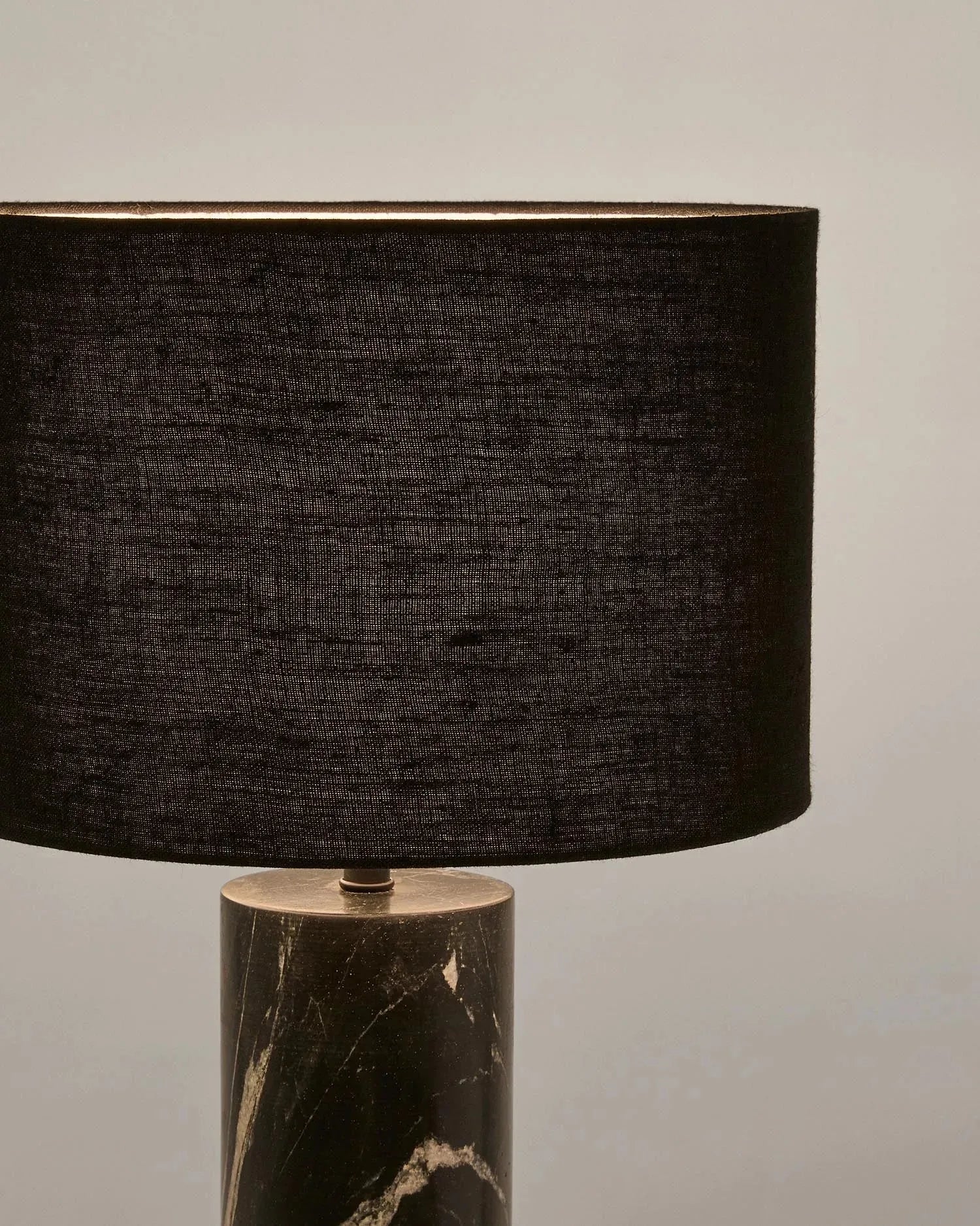 Die Tischleuchte Vex kombiniert schwarzen Marmor und Leinen für ein modernes Design, perfekt für elegante Wohnräume.