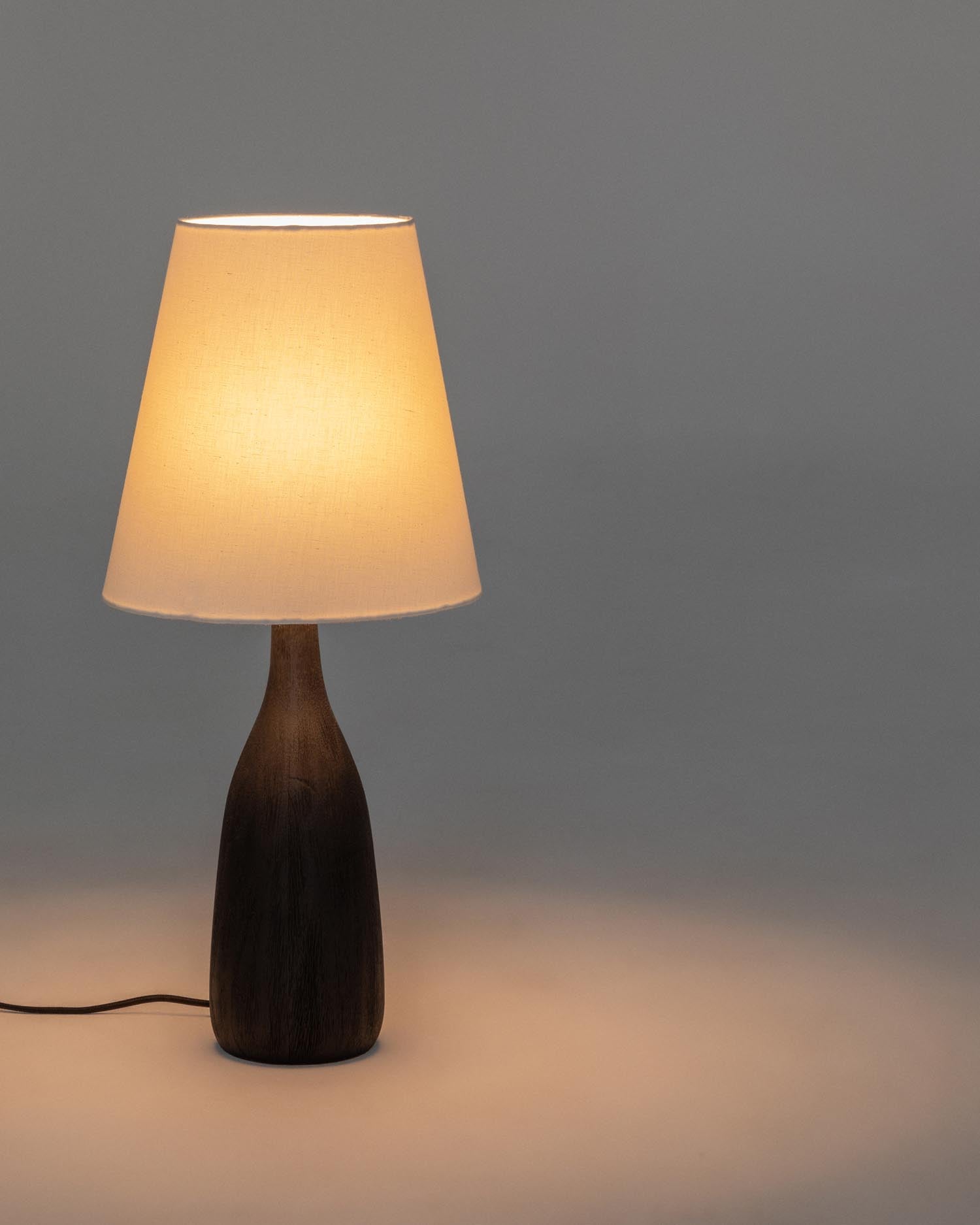 Elegante Tischleuchte Luvia aus robustem Holz mit schwarzem Finish und hellem Stoffschirm, ideal für gemütliche Akzente in jedem Raum.