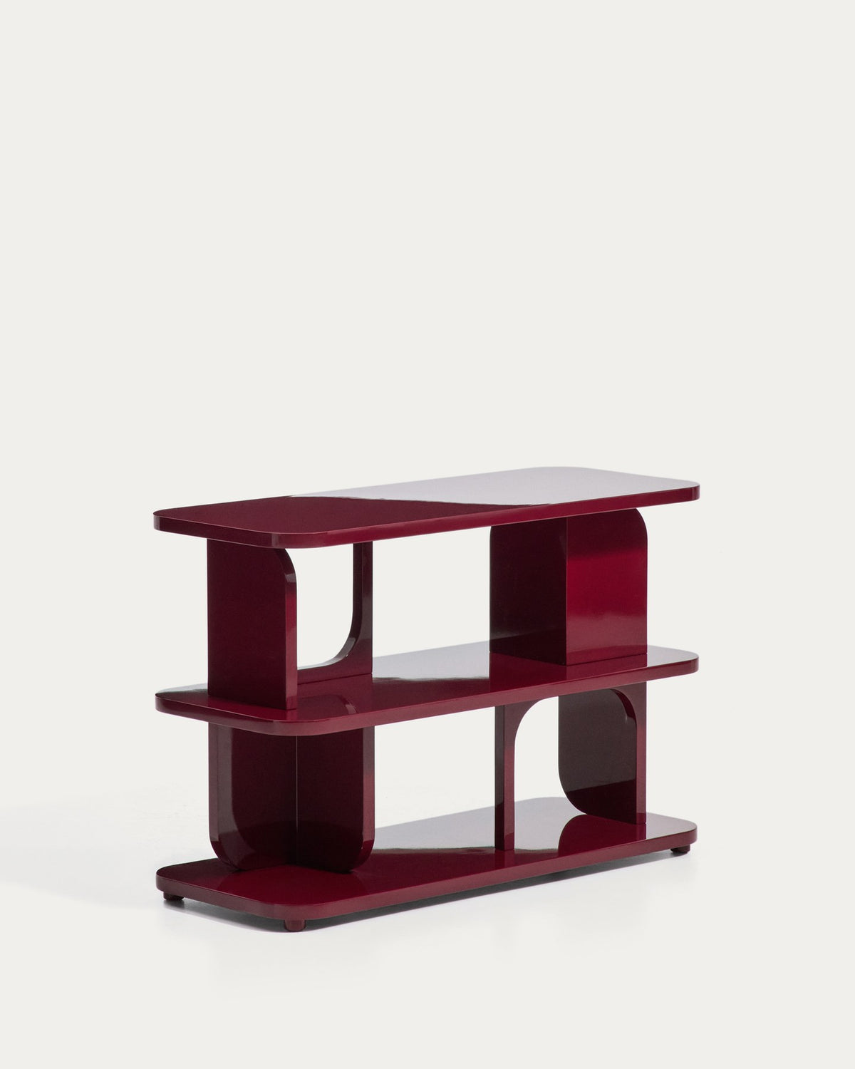Regal Aduma aus MDF und Buchenholz mit granatroter Glanzlackierung, geschwungene Form mit offenen Fächern und verstellbaren Beinen.