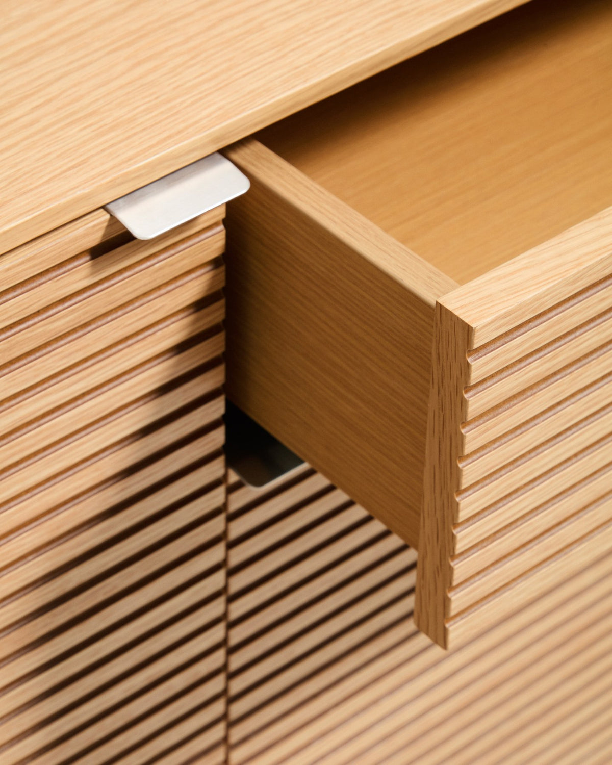 Braunes Sideboard Norlen mit vier Türen, zwei Schubladen und Eichenfurnier, abgerundete Ecken, Holzunterbau mit vier Beinen.