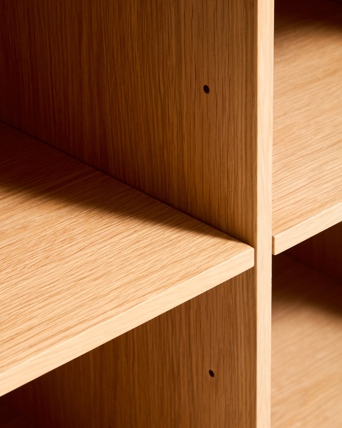 Braunes Highboard Norlen mit 4 Türen aus Eichenfurnier und MDF, naturfarbenes Finish, abgerundete Ecken, Beinhöhe 14 cm.