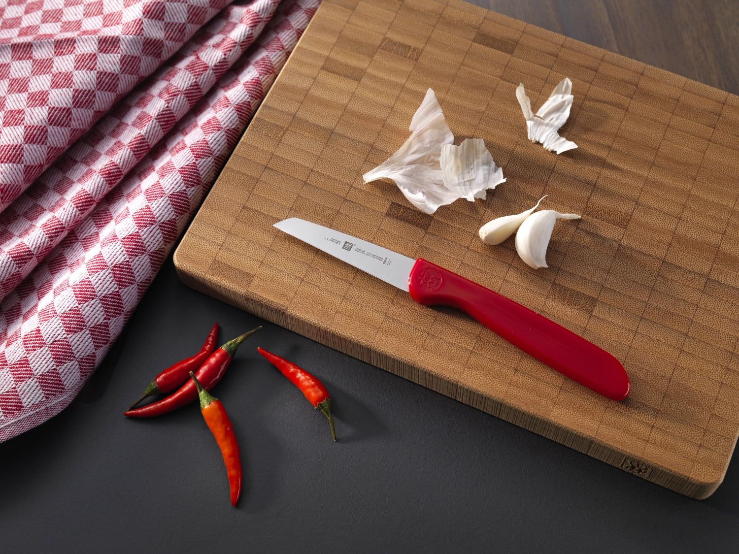 Erleben Sie das Twin Grip Gemüsemesser von Zwilling in elegantem Rot. Die 70 mm Klinge und der ergonomische Griff garantieren müheloses Schneiden von Gemüse und Obst.