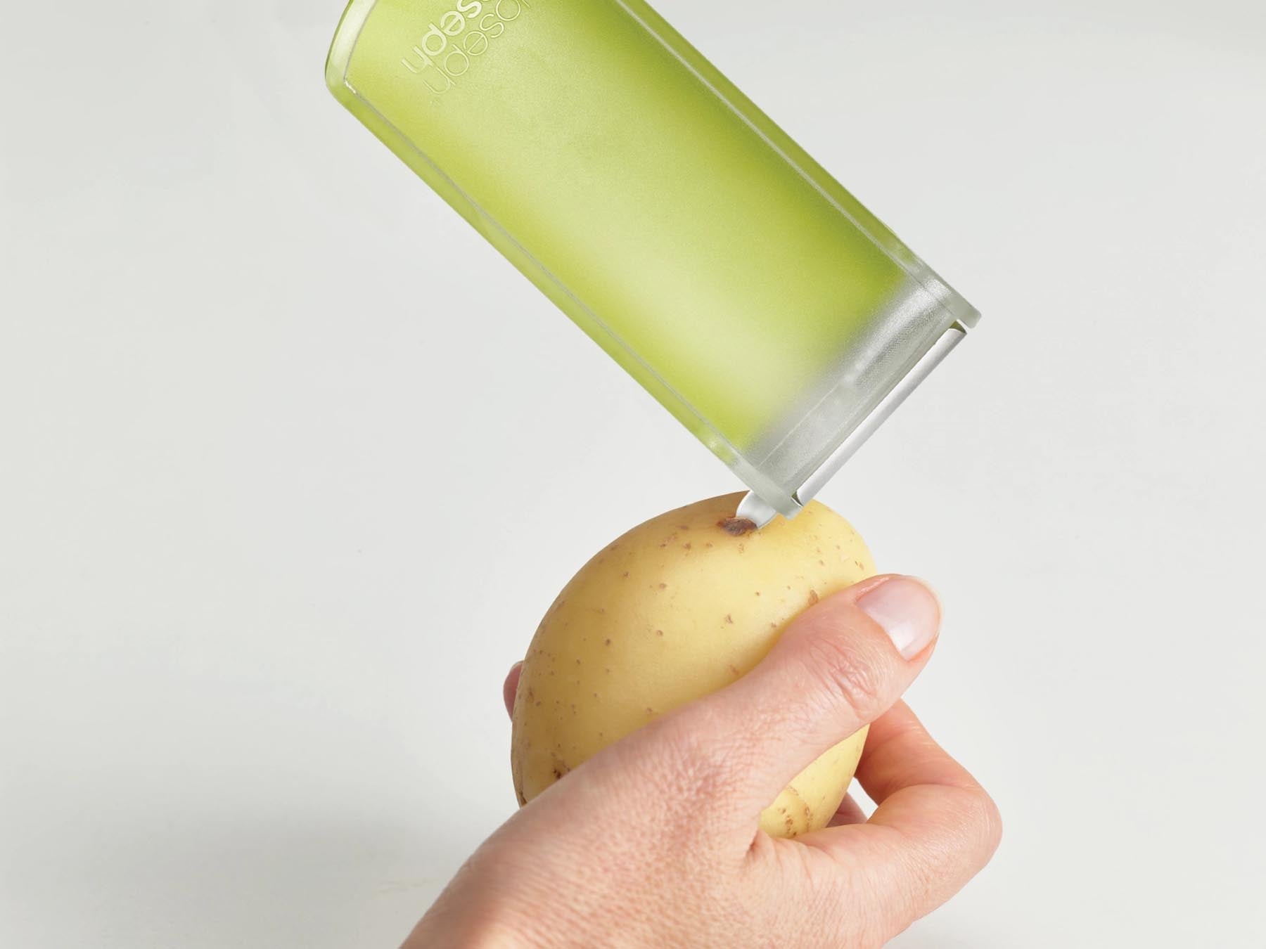 Innovativer Joseph Joseph PeelStore Schäler mit cleverer Abfallschale, ideal für schnelles und sauberes Schälen von Obst und Gemüse.