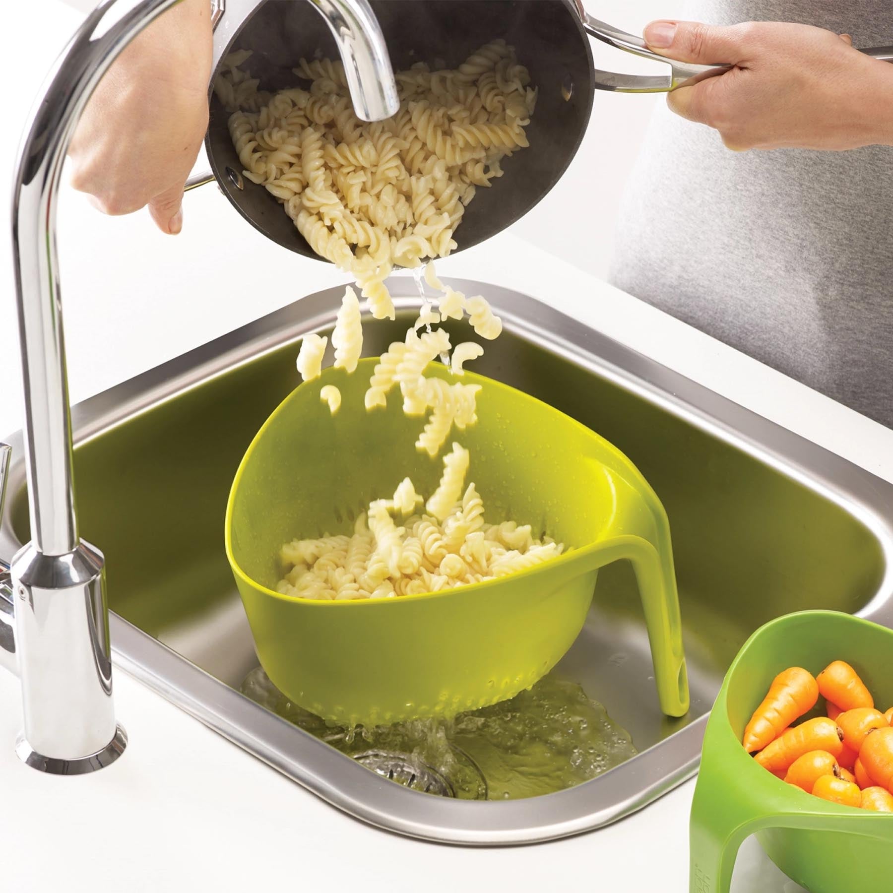 Zwei stilvolle grüne Küchensiebe von Joseph Joseph, ideal zum Abtropfen und Zubereiten von Lebensmitteln, vereinen Funktionalität und modernes Design.