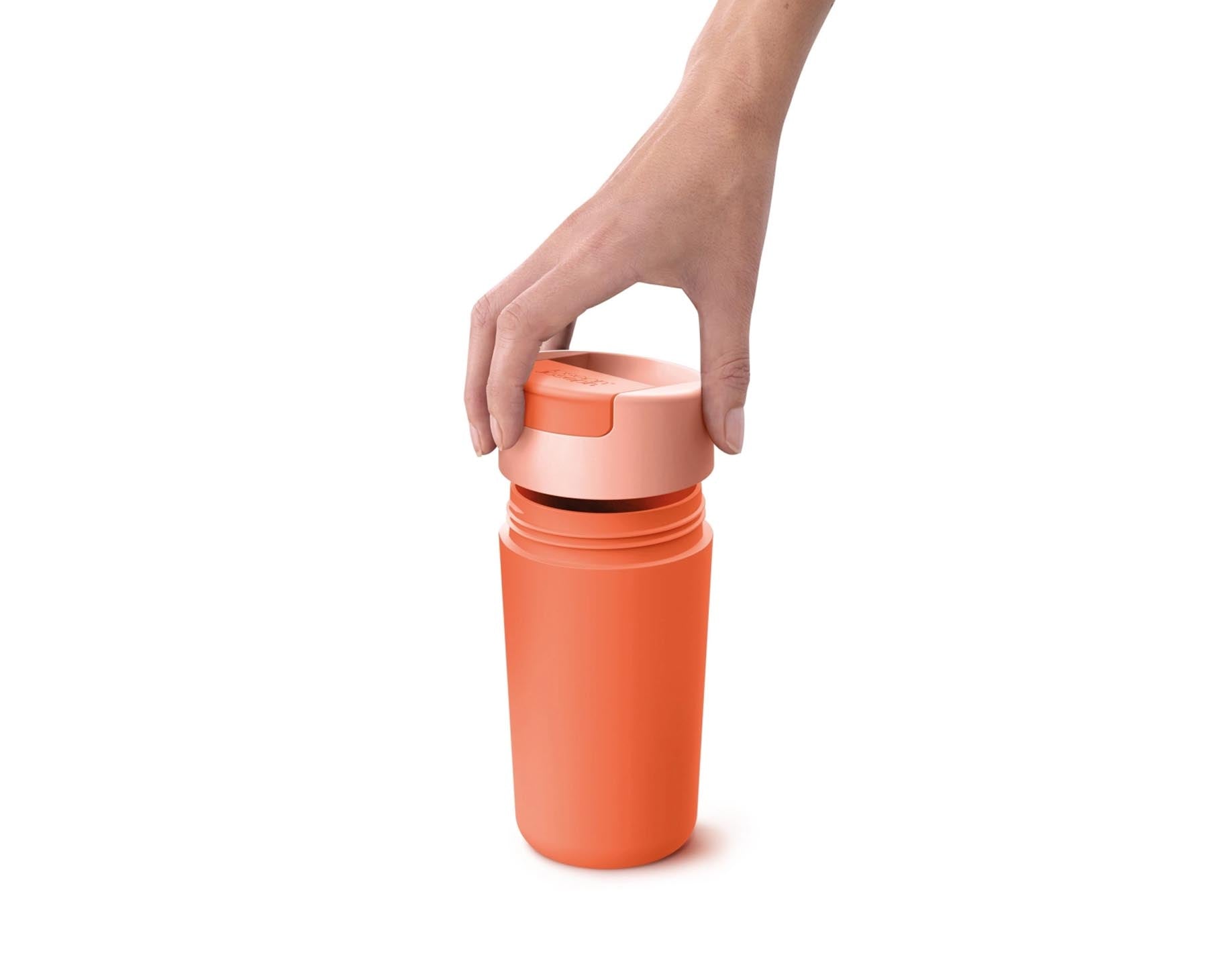 Stylischer Sipp Reisebecher in strahlendem Koralle, perfekt für unterwegs. Mit einem innovativen Klappdeckel für komfortables Trinken.