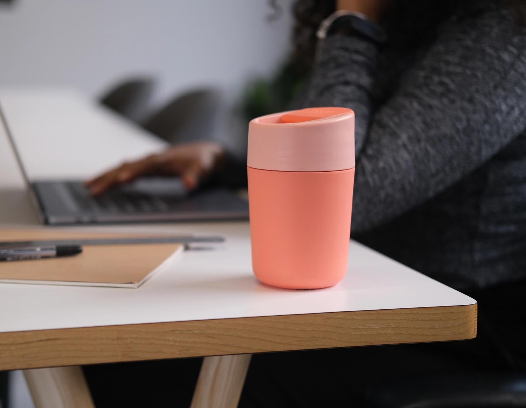 Stylischer Sipp Reisebecher in Koralle mit praktischem Klappdeckel, ideal für unterwegs. Perfekt für heiße und kalte Getränke.