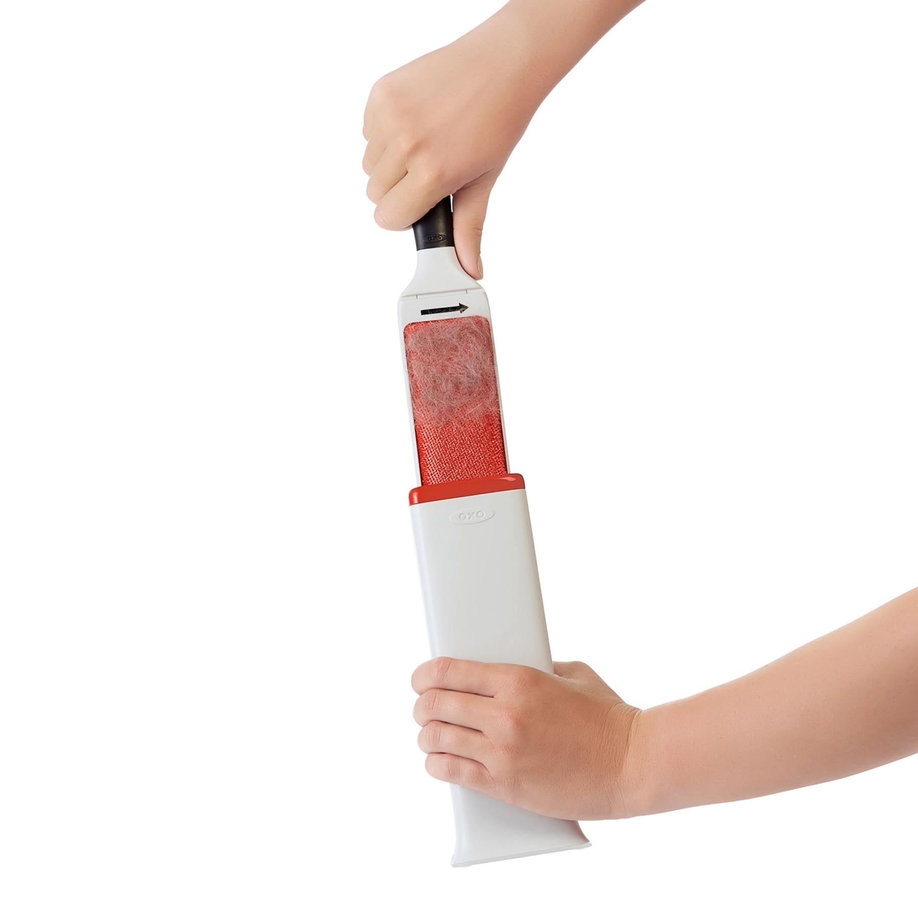 Effiziente Flusenentferner Bürste in ansprechendem Weiß-Orange von OXO, perfekt für die mühelose Reinigung von Möbeln und Textilien.