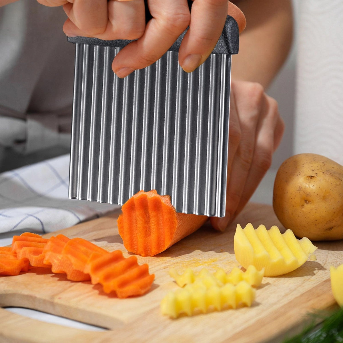 Grauer Wellen- und Buntschneider Master Line von Westmark, kompaktes Küchenwerkzeug zum Schneiden von Wellenformen aus Gemüse und Früchten.