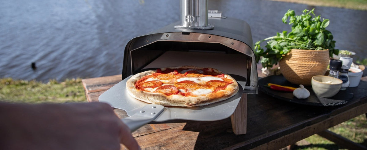 Schwarzer Pizzaofen für Pellets von Boska mit offener Feuertasse und Brennkammer, Grösse 69.9x36 cm, Höhe 72.5 cm.