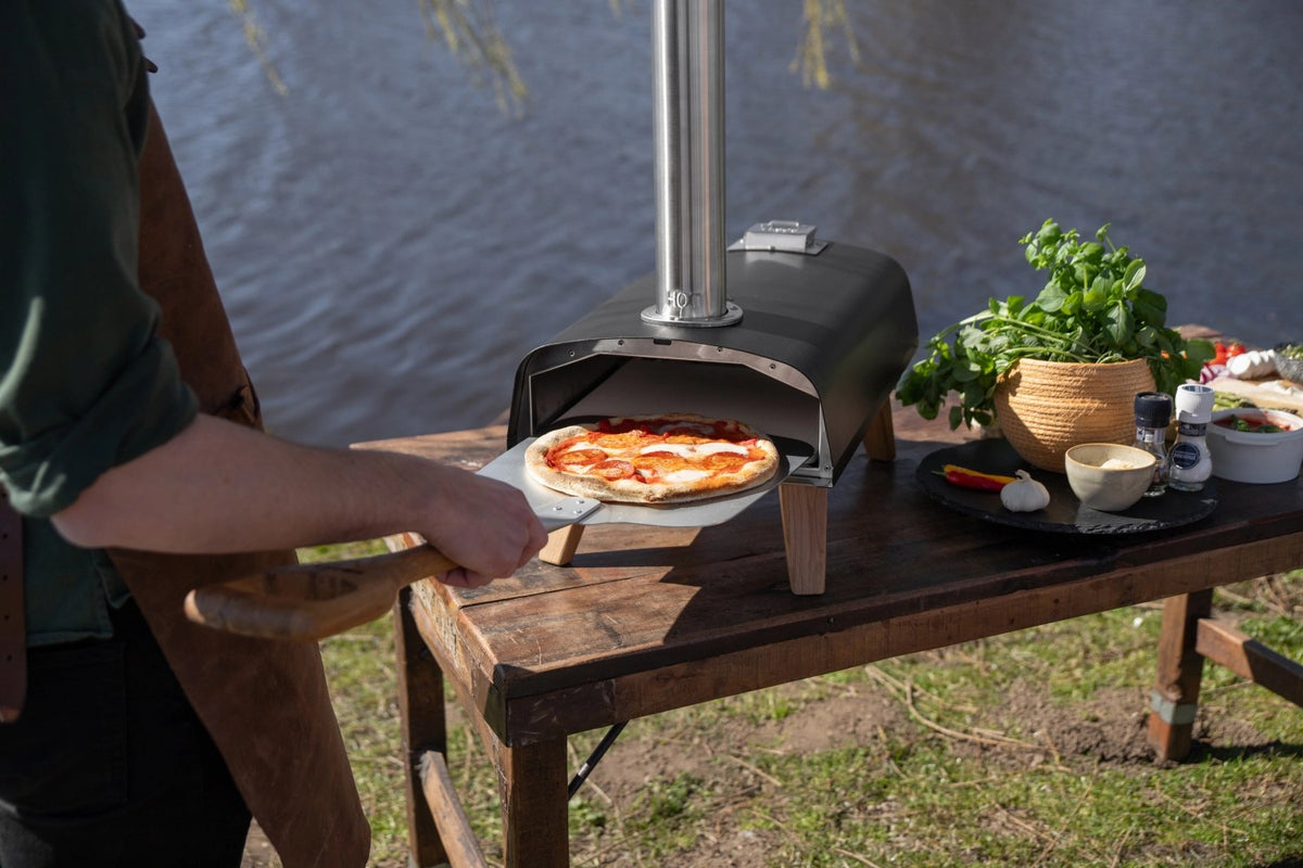 Schwarzer Pizzaofen für Pellets von Boska mit offener Feuertasse und Brennkammer, Grösse 69.9x36 cm, Höhe 72.5 cm.
