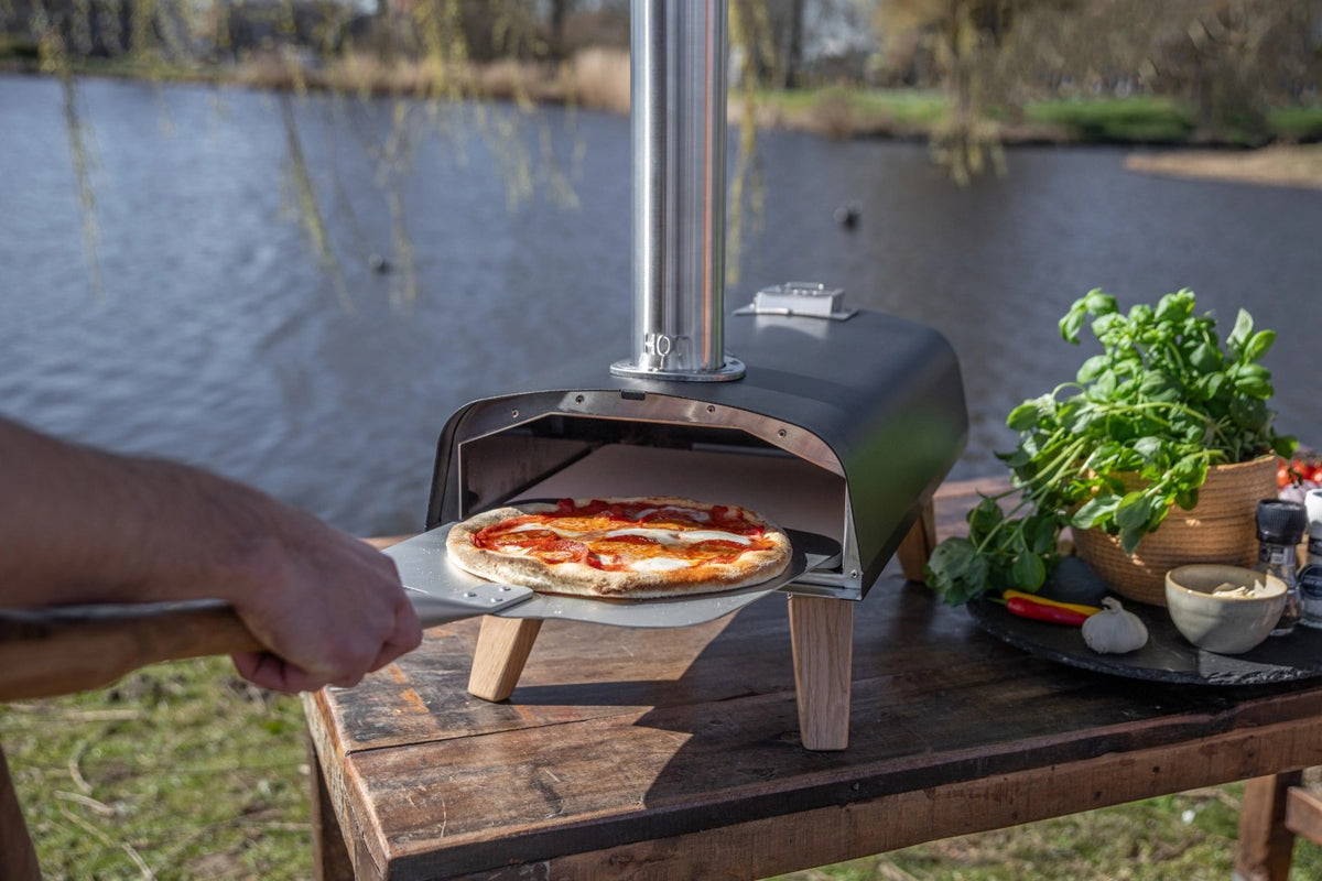Schwarzer Pizzaofen für Pellets von Boska mit offener Feuertasse und Brennkammer, Grösse 69.9x36 cm, Höhe 72.5 cm.
