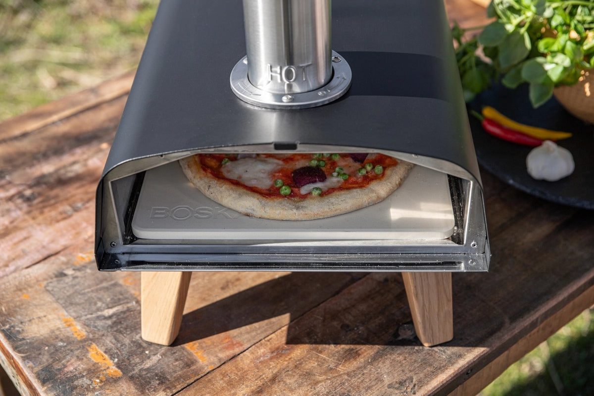 Schwarzer Pizzaofen für Pellets von Boska mit offener Feuertasse und Brennkammer, Grösse 69.9x36 cm, Höhe 72.5 cm.