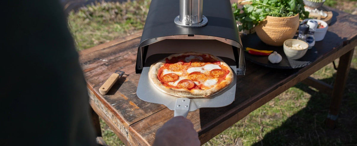 Schwarzer Pizzaofen für Pellets von Boska mit offener Feuertasse und Brennkammer, Grösse 69.9x36 cm, Höhe 72.5 cm.