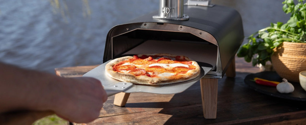 Schwarzer Pizzaofen für Pellets von Boska mit offener Feuertasse und Brennkammer, Grösse 69.9x36 cm, Höhe 72.5 cm.
