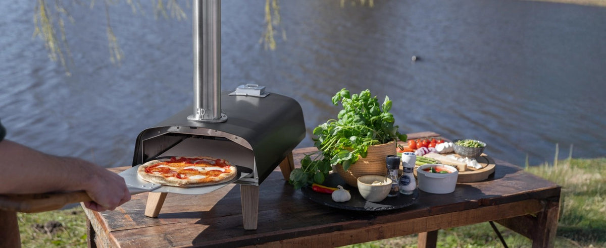 Schwarzer Pizzaofen für Pellets von Boska mit offener Feuertasse und Brennkammer, Grösse 69.9x36 cm, Höhe 72.5 cm.