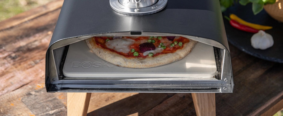 Schwarzer Pizzaofen für Pellets von Boska mit offener Feuertasse und Brennkammer, Grösse 69.9x36 cm, Höhe 72.5 cm.