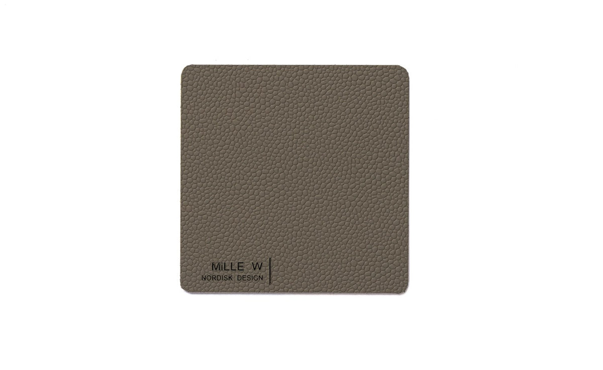 Rechteckiger Untersetzer in Grau, Masse 10 x 10 x 0.2 cm, als Pfannenuntersatz von MiLLE W NORDISK DESIGN, flache kompakte Form.