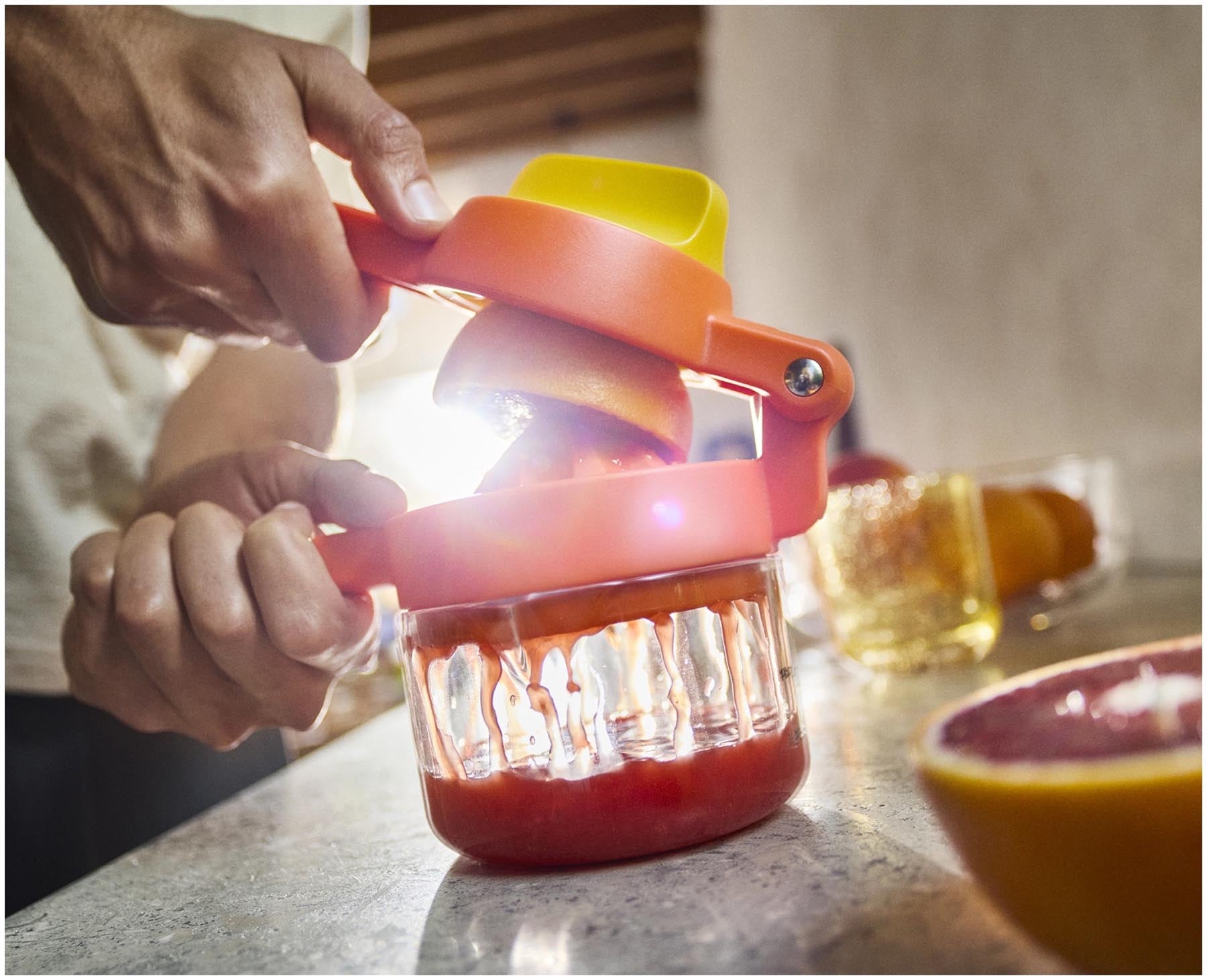 Die JuiceMax Plus Citrus Presse in leuchtendem Orange von Joseph Joseph, ideal für frischen Saft aus Orangen und Zitronen.