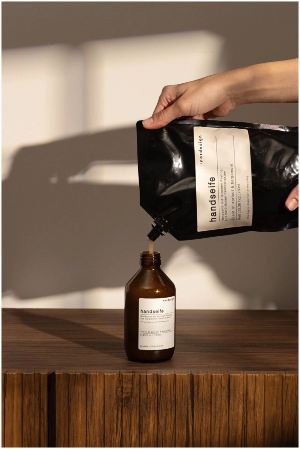 Braune Handseife im Spender, 250ml, Duft Apricot & Bergamot, Masse 6x6x18cm, Marke Nordesign, mit Peeling-Effekt aus Oliven-Kernextrakten.