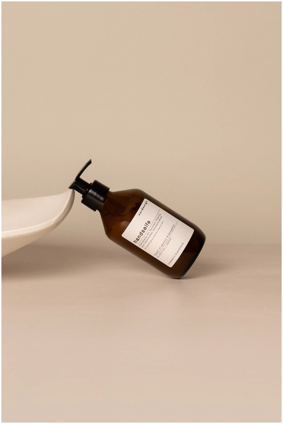 Braune Handseife im Spender, 250ml, Duft Apricot & Bergamot, Masse 6x6x18cm, Marke Nordesign, mit Peeling-Effekt aus Oliven-Kernextrakten.
