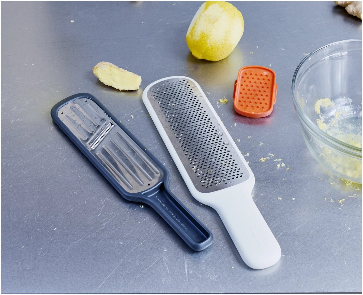 Graues Joseph Joseph Nest Slice & Zest Set aus Mini-Mandoline und Zestenreibe mit Stachelhalter und Schutzhülle, kompakt zusammengeklipst