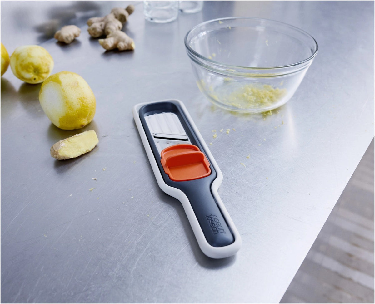 Graues Joseph Joseph Nest Slice & Zest Set aus Mini-Mandoline und Zestenreibe mit Stachelhalter und Schutzhülle, kompakt zusammengeklipst