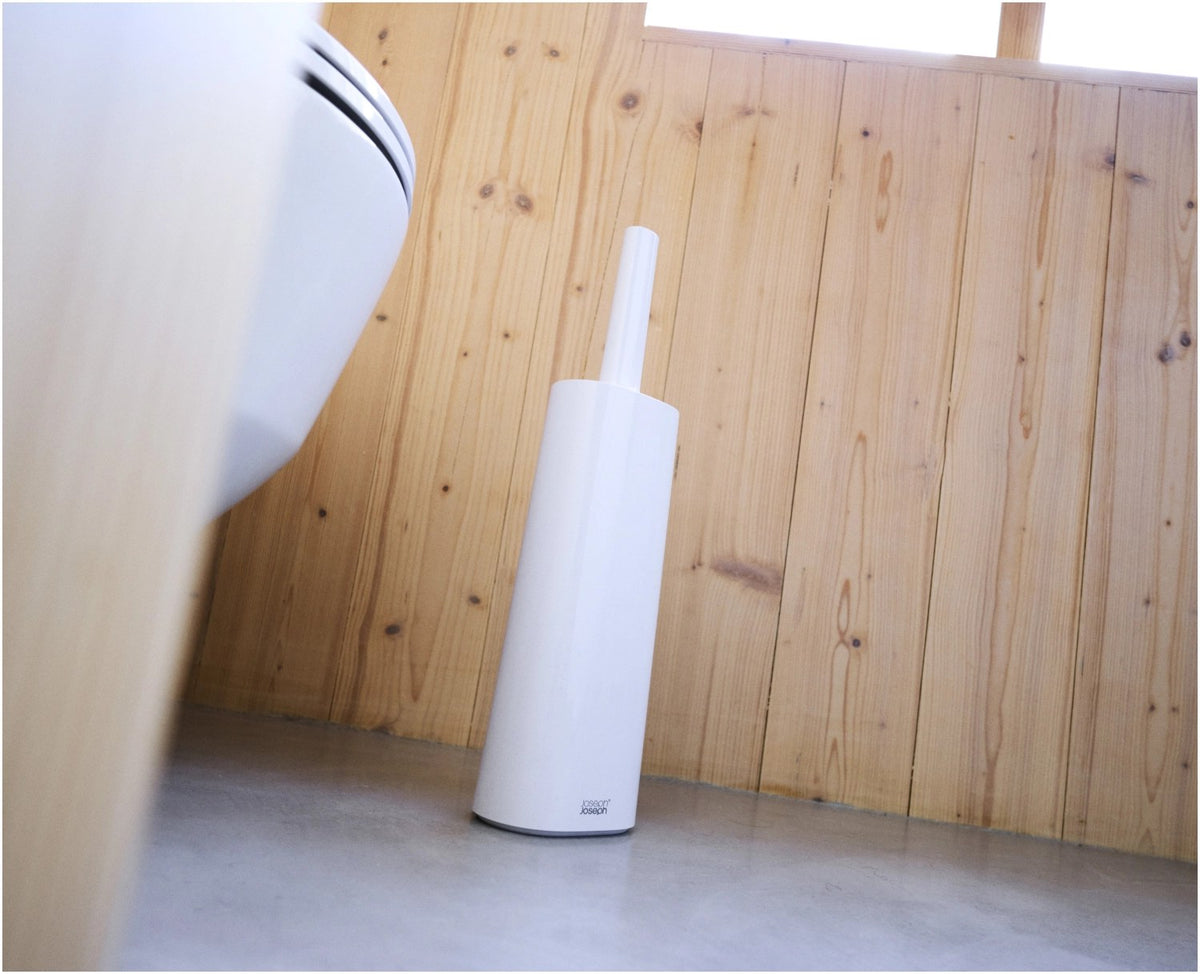 Weisse WC-Bürste Flex TriBlade von Joseph Joseph mit passendem geschlossenem Halter, schlanke Form, glänzende Oberfläche, freistehend im Badezimmer.